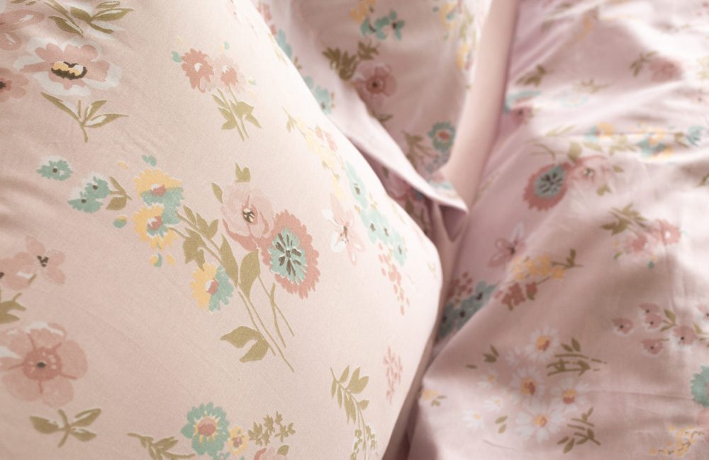 Foto detalhe de lençóis em estampa floral rosa.